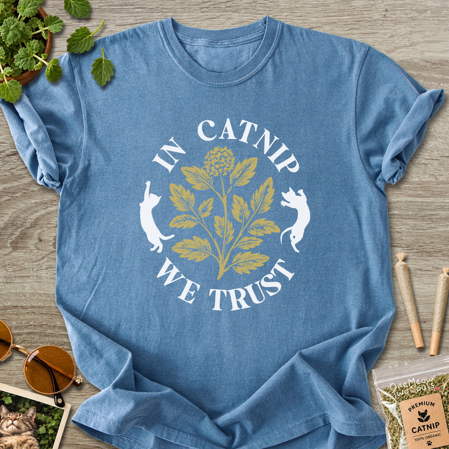 Blue Jean colored Comfort Colors 1717 cotton T-shirt, featuring a "In Catnip We Trust" funny cat design illustration. One Meow Two Souls brand.