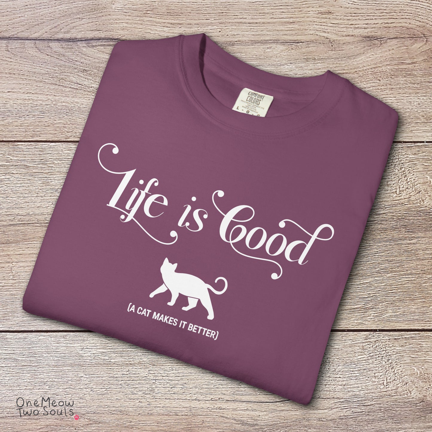 Berry colored Comfort Colors 1717 cotton T-shirt, featuring a "Life is good. A cat makes it better" funny cat design illustration. One Meow Two Souls brand.