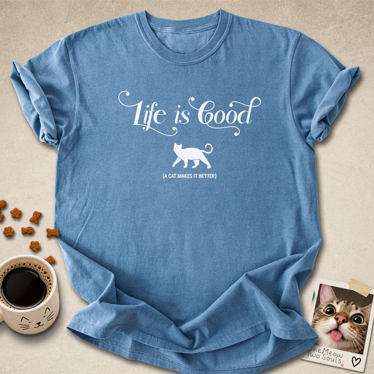 Blue jean colored Comfort Colors 1717 cotton T-shirt, featuring a "Life is good. A cat makes it better" funny cat design illustration. One Meow Two Souls brand.