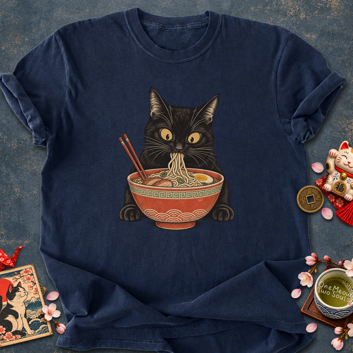 Navy colored Comfort Colors 1717 cotton T-shirt, featuring a Black cat eating Japanese ramen noodles. Funny cat design illustration. One Meow Two Souls brand.