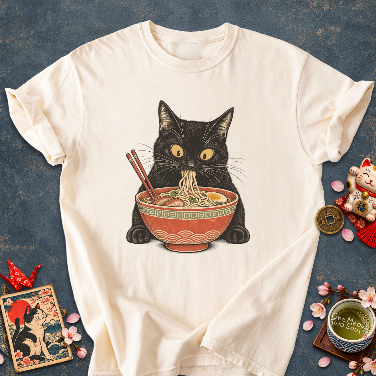 Ivory colored Comfort Colors 1717 cotton T-shirt, featuring a Black cat eating Japanese ramen noodles. Funny cat design illustration. One Meow Two Souls brand.