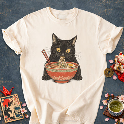 Ivory colored Comfort Colors 1717 cotton T-shirt, featuring a Black cat eating Japanese ramen noodles. Funny cat design illustration. One Meow Two Souls brand.