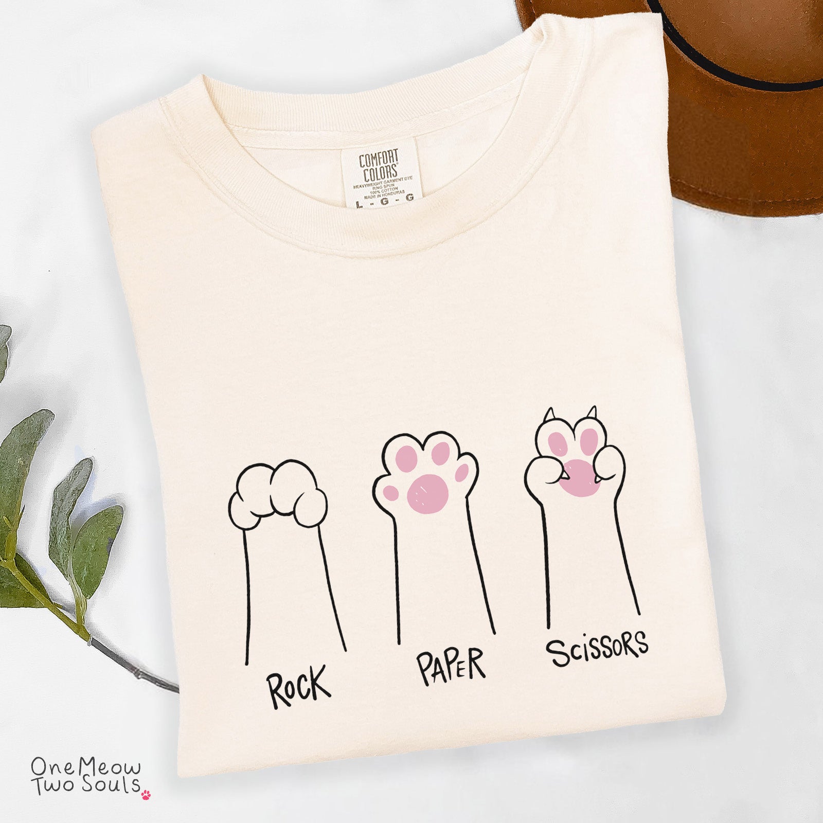 Ivory colored Comfort Colors 1717 cotton T-shirt, presenting a "Rock Paper Scissors" funny cat design. One Meow Two Souls brand.