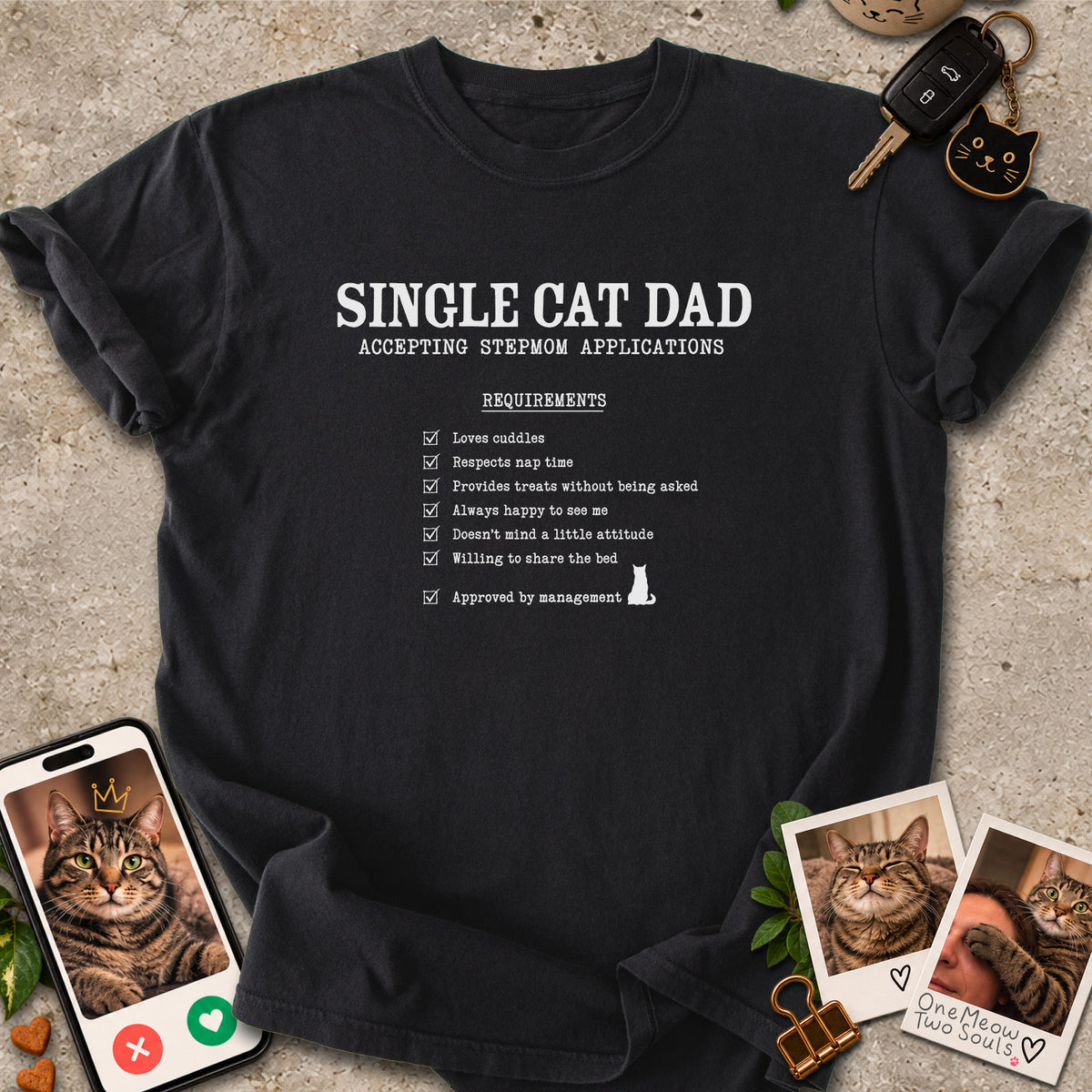 Black colored Comfort Colors 1717 cotton T-shirt, featuring a "Single cat dad accepting stepmom applications" funny cat design illustration. One Meow Two Souls brand.