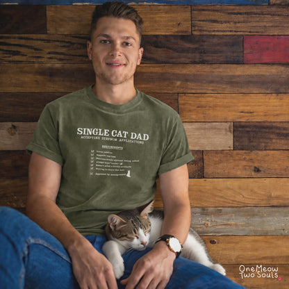 Moss colored Comfort Colors 1717 cotton T-shirt, featuring a "Single cat dad accepting stepmom applications" funny cat design illustration. One Meow Two Souls brand.