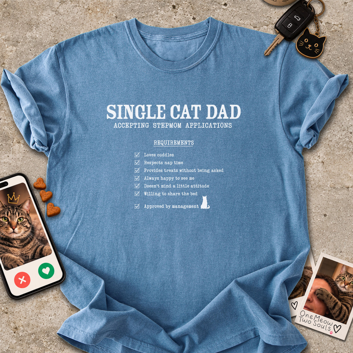 Blue Jean colored Comfort Colors 1717 cotton T-shirt, featuring a "Single cat dad accepting stepmom applications" funny cat design illustration. One Meow Two Souls brand.