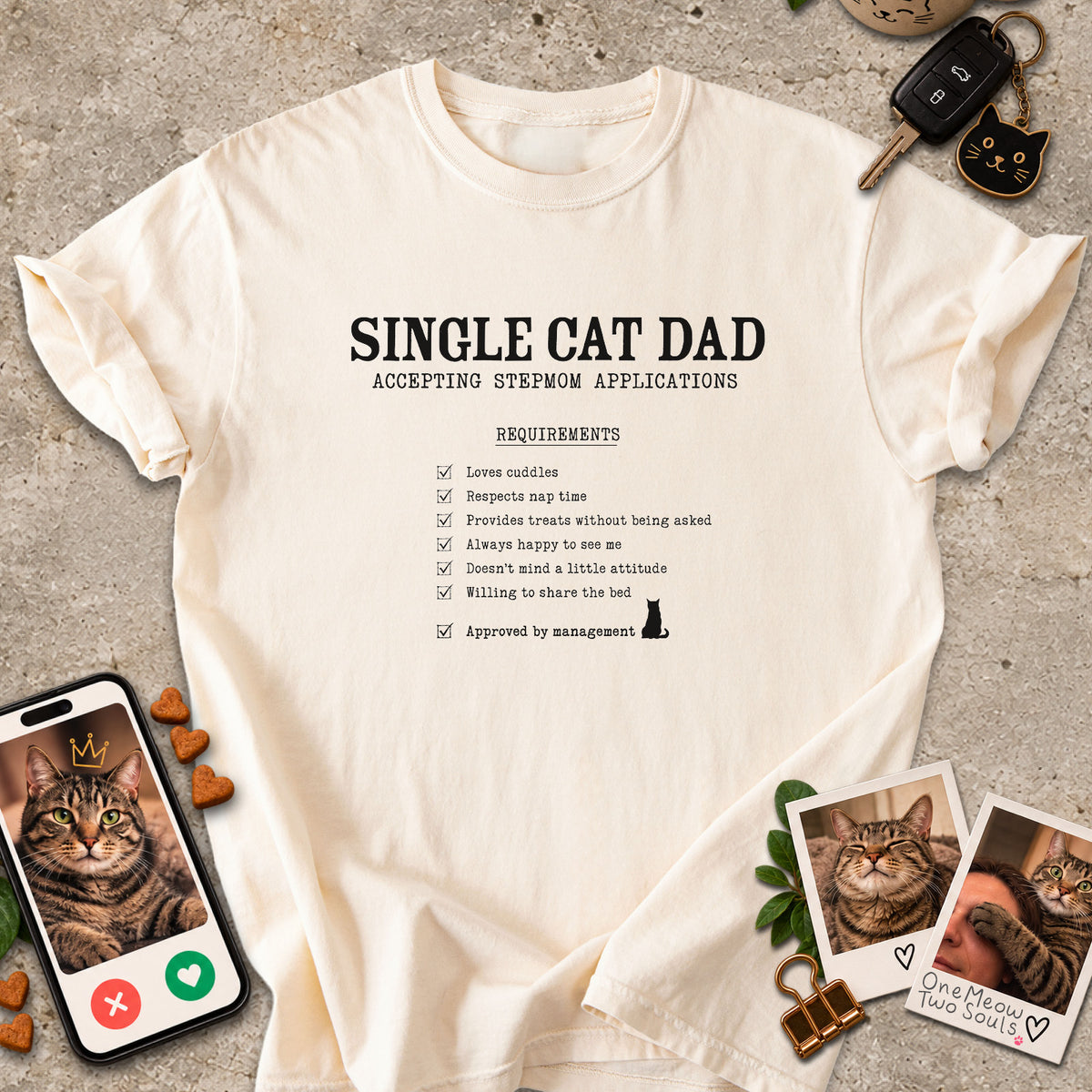 Ivory colored Comfort Colors 1717 cotton T-shirt, featuring a "Single cat dad accepting stepmom applications" funny cat design illustration. One Meow Two Souls brand.