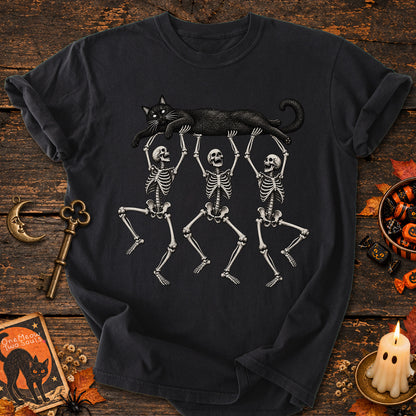 Black colored Comfort Colors 1717 cotton T-shirt, featuring a Black cat carried by three skeletons funny cat Halloween design illustration. One Meow Two Souls brand.