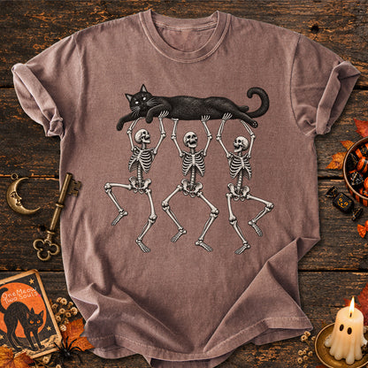 Espresso colored Comfort Colors 1717 cotton T-shirt, featuring a Black cat carried by three skeletons funny cat Halloween design illustration. One Meow Two Souls brand.