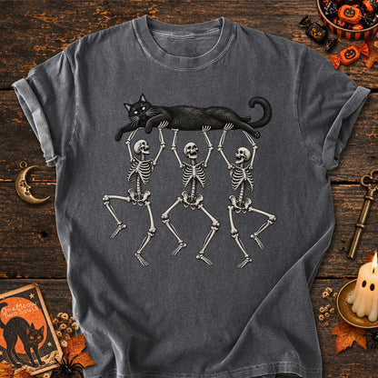 Pepper colored Comfort Colors 1717 cotton T-shirt, featuring a Black cat carried by three skeletons funny cat Halloween design illustration. One Meow Two Souls brand.