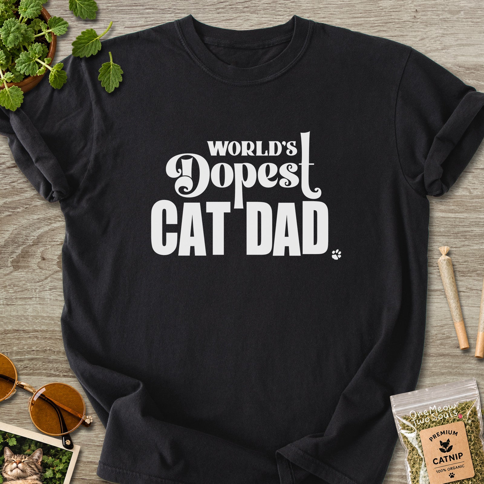 Black colored Comfort Colors 1717 cotton T-shirt, featuring a "World's Dopest Cat Dad" funny cat design illustration. One Meow Two Souls brand.