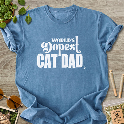 Blue Jean colored Comfort Colors 1717 cotton T-shirt, featuring a "World's Dopest Cat Dad" funny cat design illustration. One Meow Two Souls brand.