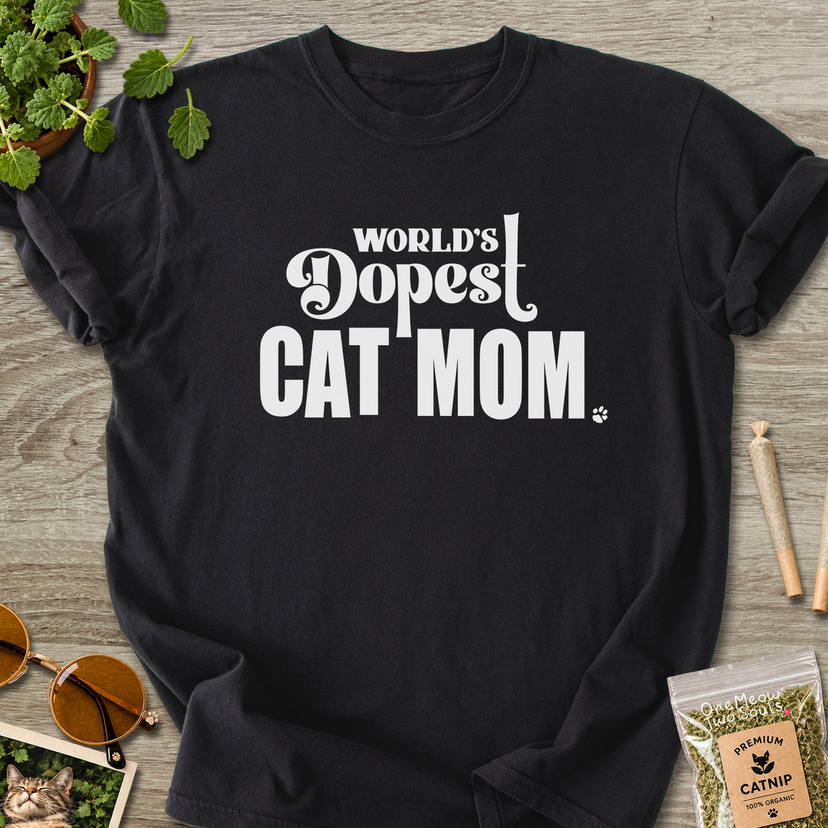 Black colored Comfort Colors 1717 cotton T-shirt, featuring a "World's Dopest Cat Mom" funny cat design illustration. One Meow Two Souls brand.