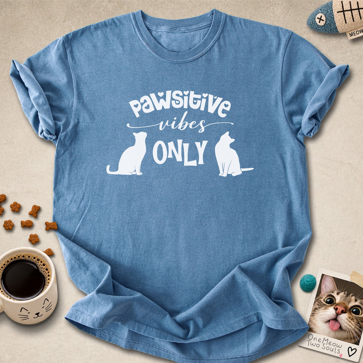 Blue Jean colored Comfort Colors 1717 cotton T-shirt, featuring a "Pawsitive Vibes Only" funny cat design illustration. One Meow Two Souls brand.