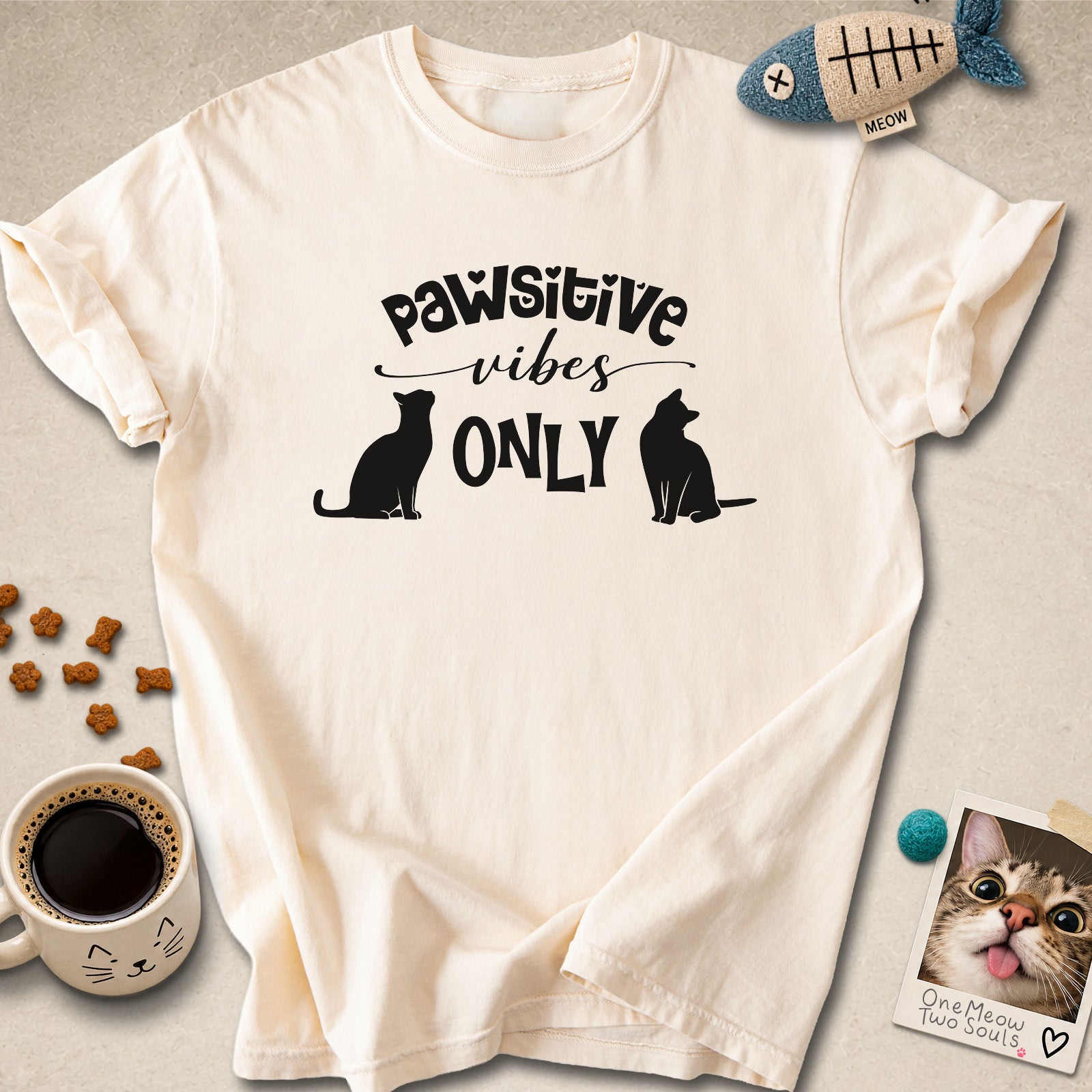 Ivory colored Comfort Colors 1717 cotton T-shirt, featuring a "Pawsitive Vibes Only" funny cat design illustration. One Meow Two Souls brand.