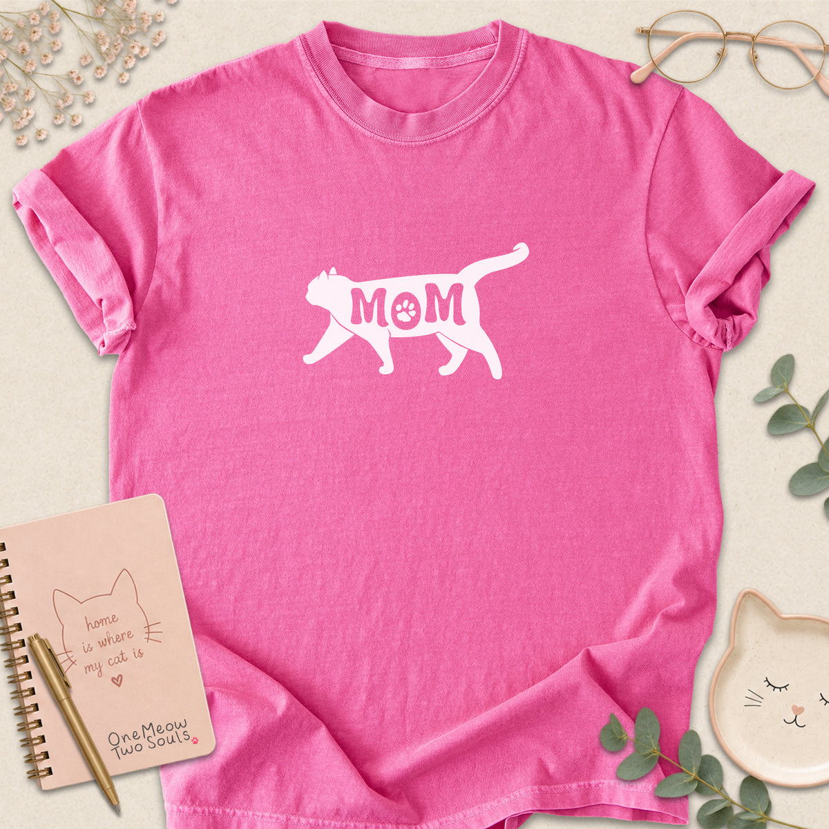 Crunchberry color Comfort Colors 1717 short-sleeve t-shirt with a white cat silhouette and the word 'MOM' across the chest. One Meow Two Souls brand.