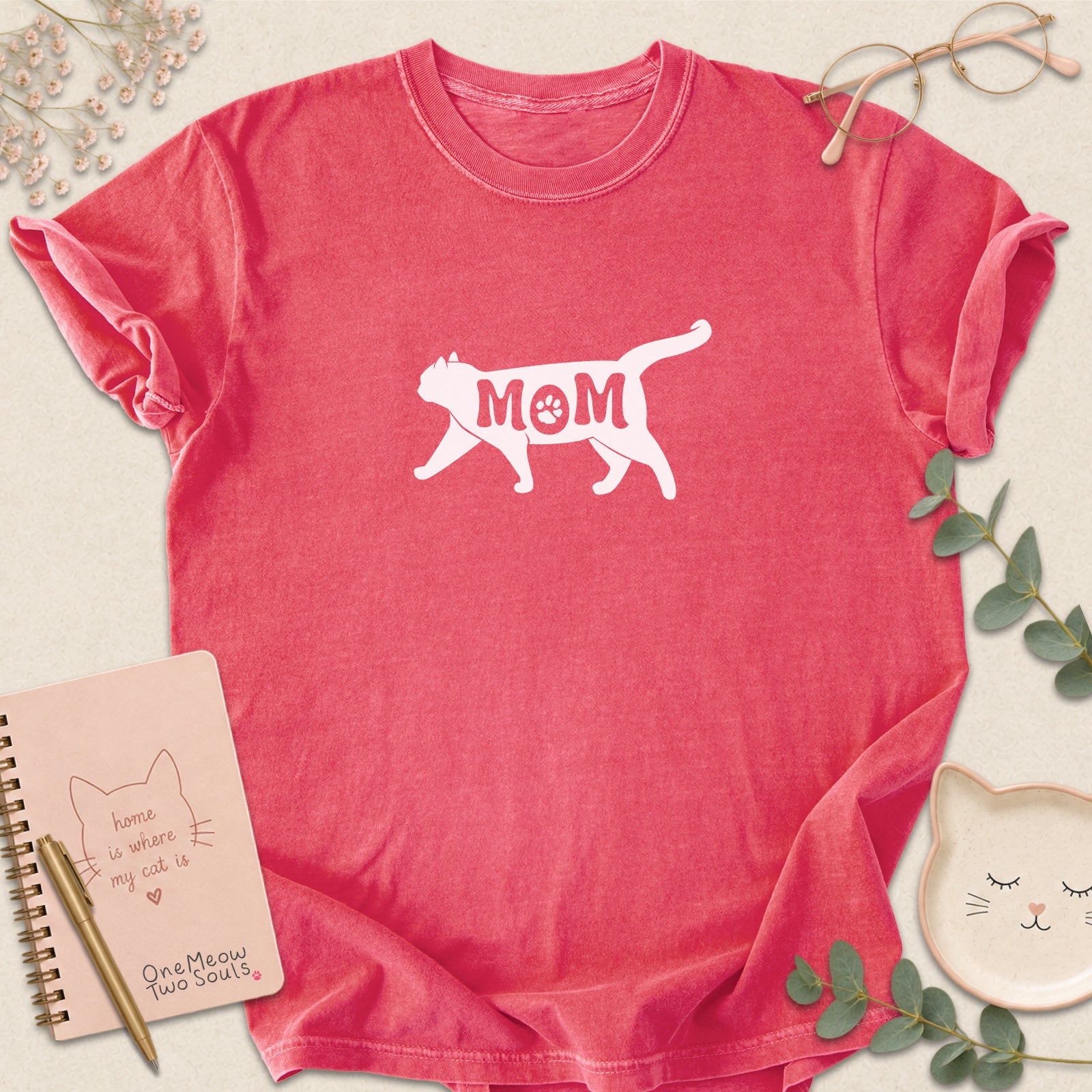 Watermelon color Comfort Colors 1717 short-sleeve t-shirt with a white cat silhouette and the word 'MOM' across the chest. One Meow Two Souls brand.