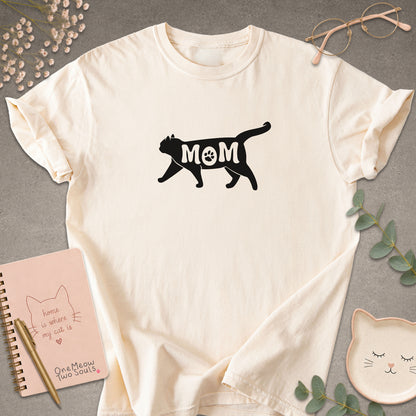 Ivory color Comfort Colors 1717 short-sleeve t-shirt with a white cat silhouette and the word 'MOM' across the chest. One Meow Two Souls brand.